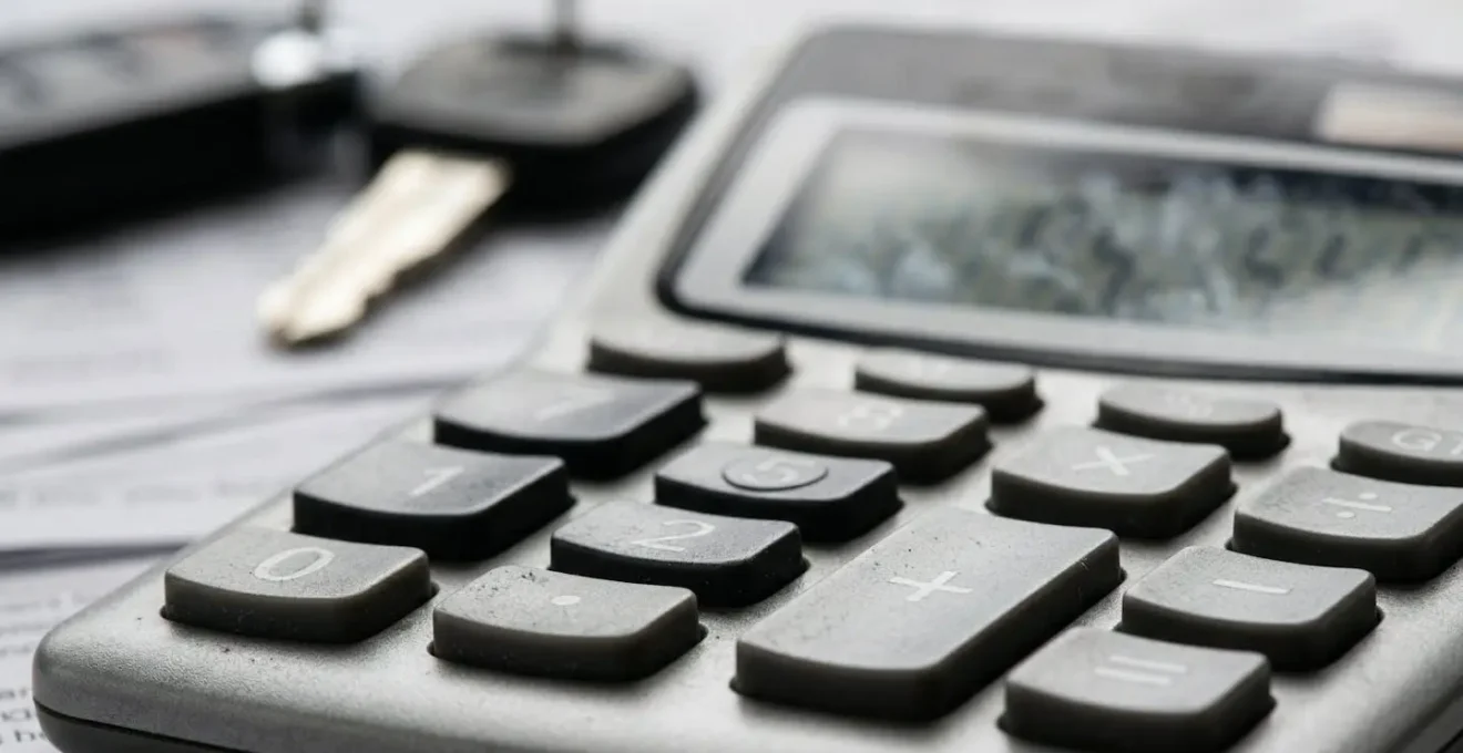 Scène de bureau avec documents financiers et calculatrice pour évaluer les options de financement automobile