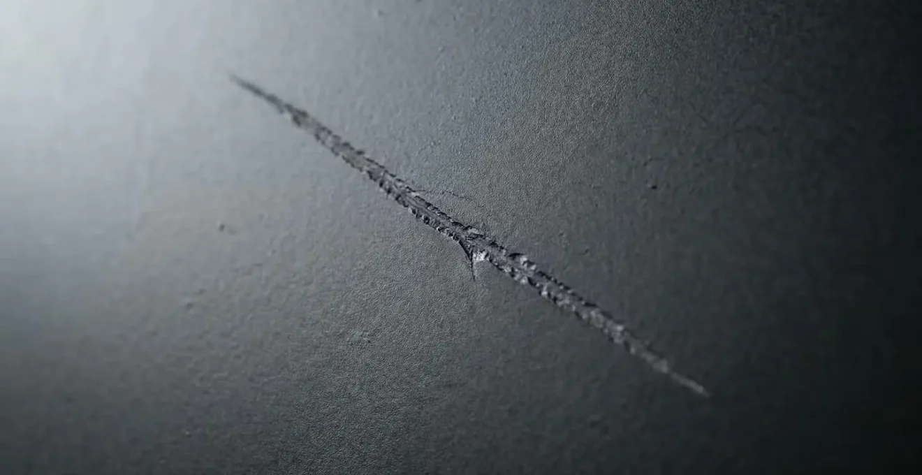 Analyse macro détaillée d'une rayure sur peinture mate automobile