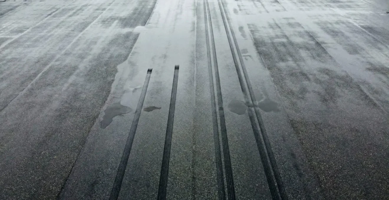 Vue aérienne d'une route mouillée avec traces de freinage montrant la différence de distance d'arrêt