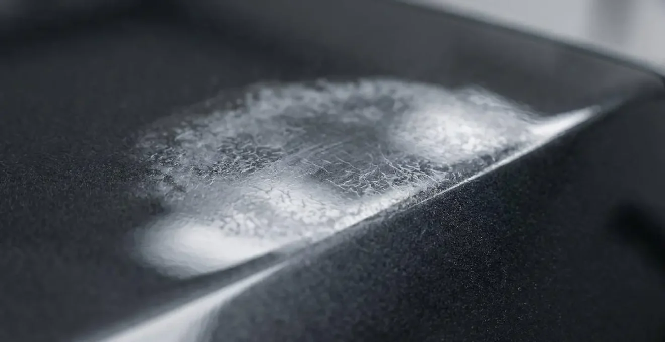 Détail macro montrant un défaut de pose céramique sur carrosserie nécessitant correction