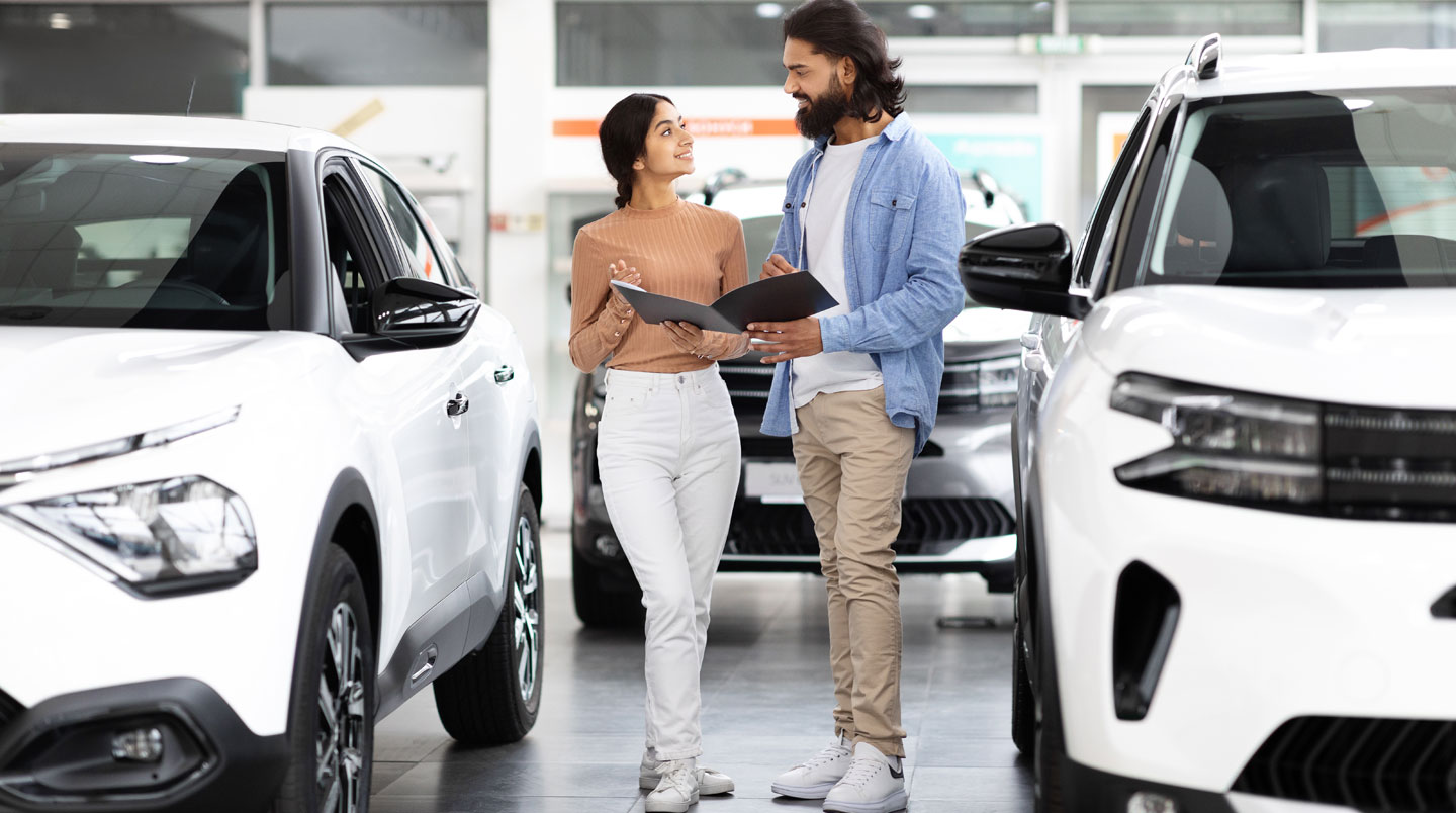 Couple comparant des devis d'assurance auto sur ordinateur dans leur salon