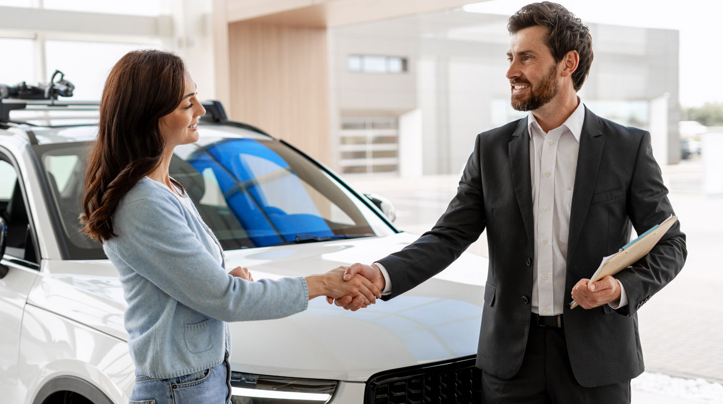 Automobiliste préparant l'achat d'un véhicule devant une concession